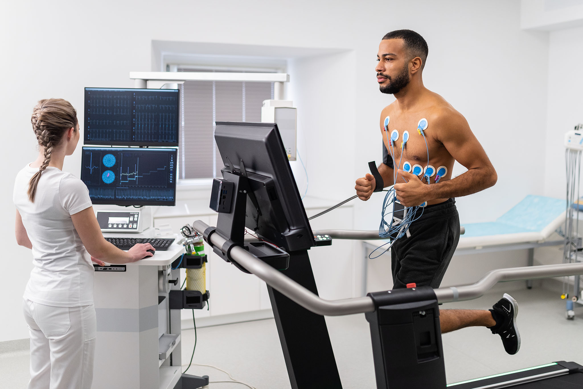 man running on treadmill conducting a test with a doctor
